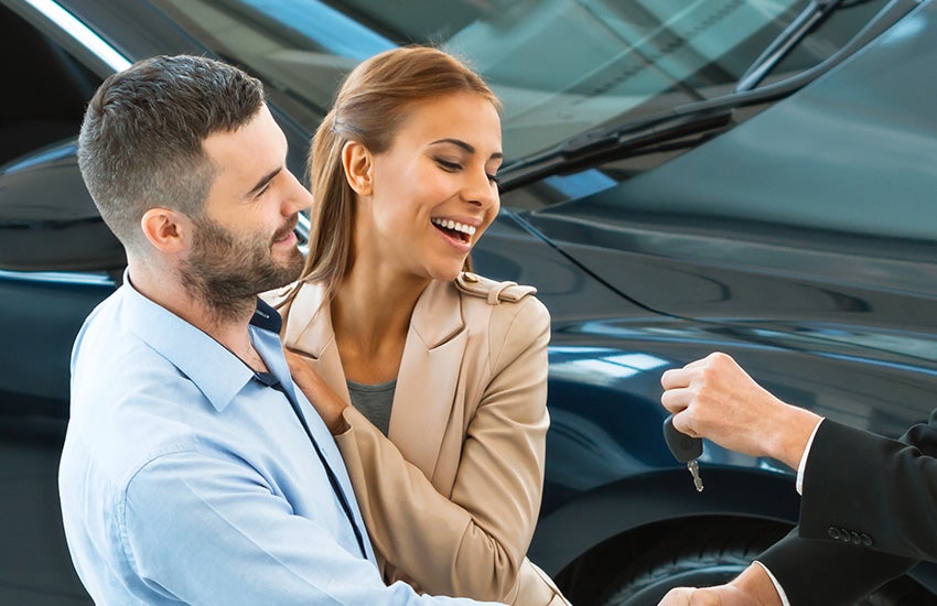 Smiling couple buying a new car